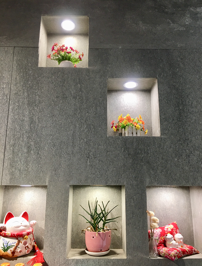 墙壁上通过镂空设计而摆放的小物件格外引入注目。