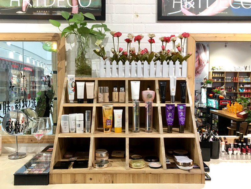 彩妆台上整齐摆放着各种试用装，并放置了植物及鲜花装饰。